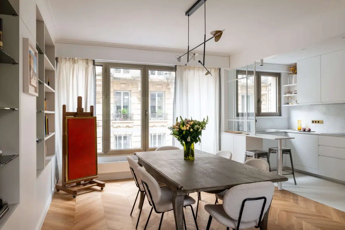 Salon d'appartement haussmannien parisien rénové par Ameo Concept avec corniches en plâtre restaurées, boiseries et parquet chêne massif